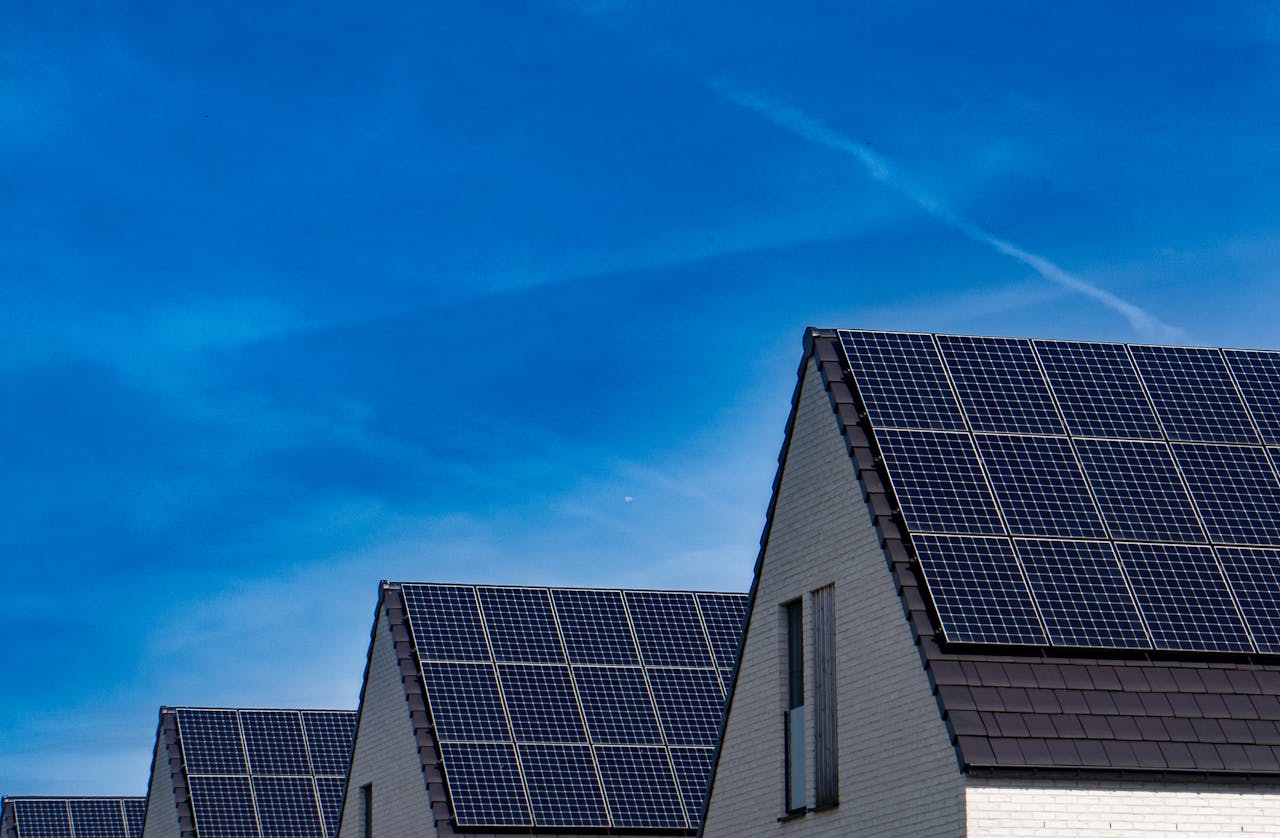 Contemporary homes featuring solar panels under a bright blue sky promoting renewable energy.